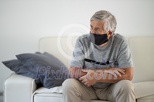Senior man wearing a facemask during coronavirus and flu outbreak. Virus and illness protection, home quarantine. COVID-19 concept Senior man wearing a facemask during coronavirus and flu outbreak. Virus and illness protection, home quarantine. COVID-19 concept