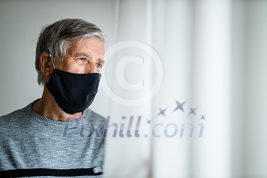 Senior man wearing a facemask during coronavirus and flu outbreak. Virus and illness protection, home quarantine. COVID-19 concept Senior man wearing a facemask during coronavirus and flu outbreak. Virus and illness protection, home quarantine. COVID-19 concept