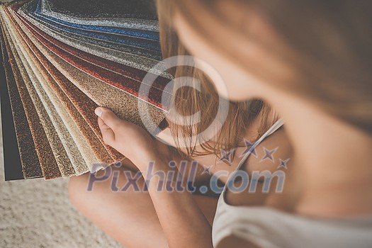 Pretty female interior designer choosing flooring and furniture materials from samples for home interior design project (shallow DOF; color toned image) Pretty female interior designer choosing flooring and furniture materials from samples for home interior design project (shallow DOF; color toned image)