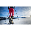 Young woman snowshoeing in high mountains, enjoying a lovely day
