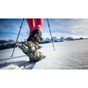 Young woman snowshoeing in high mountains, enjoying a lovely day