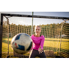 Teen female goalie catching a shot during a soccer game