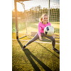 Teen female goalie catching a shot during a soccer game