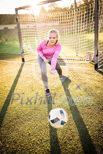 Teen female goalie catching a shot during a soccer game Teen female goalie catching a shot during a soccer game
