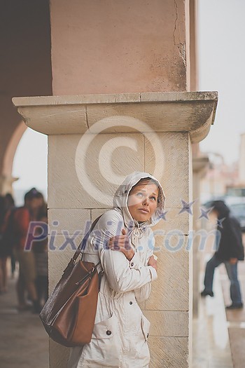 Gorgeous female tourist with a map discovering a foreign city - waiting for the rain to stop (shallow DOF; color toned image) Gorgeous female tourist with a map discovering a foreign city - waiting for the rain to stop (shallow DOF; color toned image)