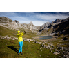 Pretty, young female hiker walking in high mountains (shallow DOF)