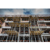 modern urban building under construction with a crane and blue sky