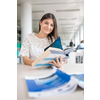 Pretty, young college student looking for a book in the library, studying for her exam