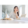 Pretty, young college student looking for a book in the library, studying for her exam