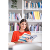 Pretty, young college student looking for a book in the library, studying for her exam