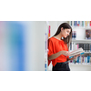 Pretty, young college student looking for a book in the library, studying for her exam