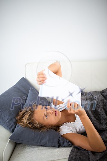 Gorgeous young woman studying at home, on her sofa Gorgeous young woman studying at home, on her sofa