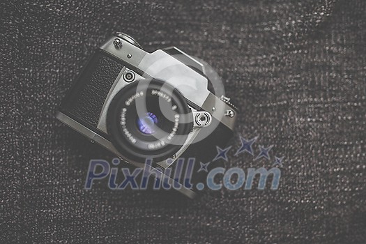 Old retro camera on vintage wooden boards abstract background with lens, close-up photo of old camera lens, image is retro filtered, selective focus Old retro camera on vintage wooden boards abstract background with lens, close-up photo of old camera lens, image is retro filtered, selective focus
