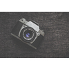 Old retro camera on vintage wooden boards abstract background with lens, close-up photo of old camera lens, image is retro filtered, selective focus