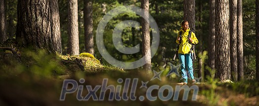 Pretty, young female hiker walking through a splendid old pine forest (shallow DOF) Pretty, young female hiker walking through a splendid old pine forest (shallow DOF)