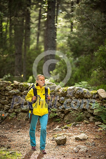 Pretty, young female hiker walking through a splendid old forest (shallow DOF) Pretty, young female hiker walking through a splendid old forest (shallow DOF)