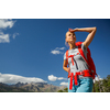 Pretty, female hiker in high mountains packing her backpack