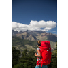 Pretty, female hiker in high mountains packing her backpack