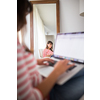 Successful young business woman sitting in a designer chair, working from home. Portrait of happy entrepreneur working on a laptop computer. Doing business remotely from the comfort of her home.