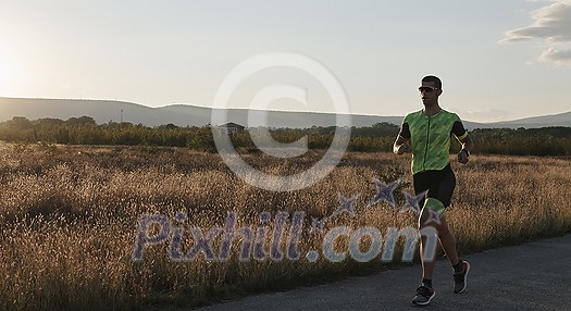 triathlon athlete running on morning training sunrise in the background triathlon athlete running on morning training sunrise in the background