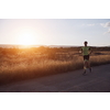 triathlon athlete running  on morning training sunrise in the background