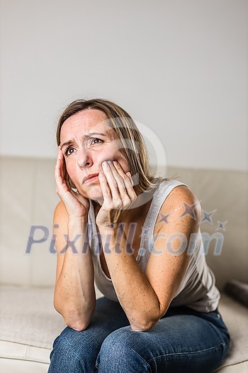 Mid-aged woman touching her cheek/mouth with painful expression because of toothache/dental issue Mid-aged woman touching her cheek/mouth with painful expression because of toothache/dental issue