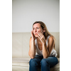 Mid-aged woman touching her cheek/mouth with painful expression because of toothache/dental issue