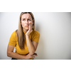 Mid-aged woman touching her cheek/mouth with painful expression because of toothache/dental issue