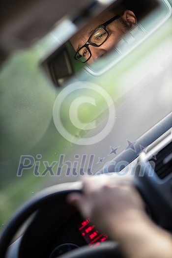 Handsome young driver driving hic car fast yet safely on the road Handsome young driver driving hic car fast yet safely on the road