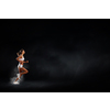 Young woman athlete running fast on dark background 
