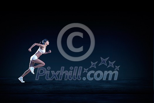 Young woman athlete running fast on dark background Young woman athlete running fast on dark background