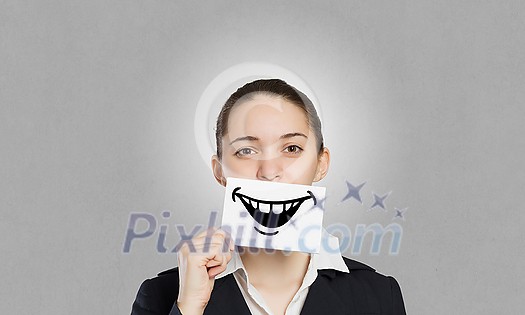 Pretty young girl holding white card with drawn smile with teeth Pretty young girl holding white card with drawn smile with teeth