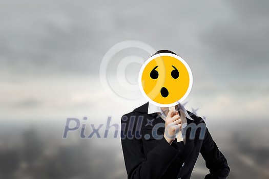 Unrecognizable businesswoman hiding her face behind sad mask Unrecognizable businesswoman hiding her face behind sad mask