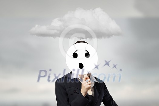 Unrecognizable businesswoman hiding her face behind sad mask Unrecognizable businesswoman hiding her face behind sad mask