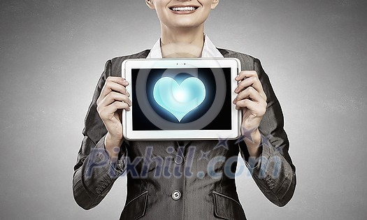 Beautiful young woman holding tablet pc with love heart Beautiful young woman holding tablet pc with love heart