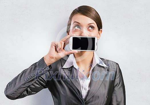Beautiful young woman holding mobile phone against her mouth and smiling Beautiful young woman holding mobile phone against her mouth and smiling