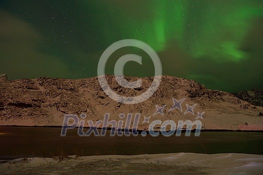 Aurora borealis Green northern lights above mountains on the Lofoten islands, Norway. Night sky with polar lights. Night winter landscape with aurora. Aurora borealis Green northern lights above mountains on the Lofoten islands, Norway. Night sky with polar lights. Night winter landscape with aurora.
