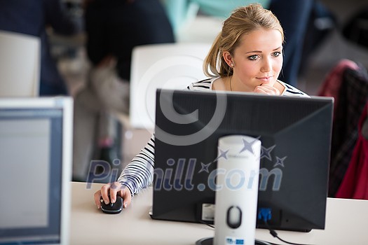 Pretty, female student looking at a desktop computer screen, learning unpleasant news about her exam results. University/office/school concept Pretty, female student looking at a desktop computer screen, learning unpleasant news about her exam results. University/office/school concept