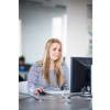 Pretty, female student looking at a desktop computer screen, learning unpleasant news about her exam results. University/office/school concept