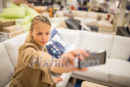 Pretty, young woman choosing the right furniture for her apartment in a modern home furnishings store (color toned image; shallow DOF) Pretty, young woman choosing the right furniture for her apartment in a modern home furnishings store (color toned image; shallow DOF)