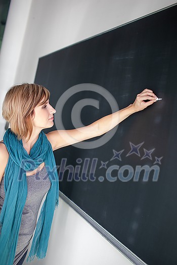 Pretty, young college student/young teacher writing on the chalkboard/blackboard during a math class (color toned image; shallow DOF) Pretty, young college student/young teacher writing on the chalkboard/blackboard during a math class (color toned image; shallow DOF)