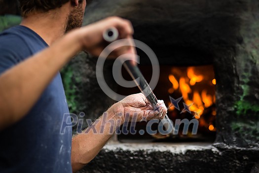 Cook baking pizza in a traditional stone wood fired oven Cook baking pizza in a traditional stone wood fired oven
