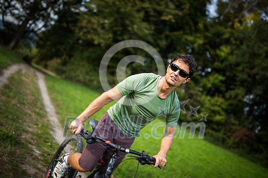 Young man riding his mountain bike outdoors on a forest path Young man riding his mountain bike outdoors on a forest path