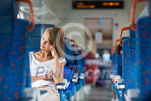 Young woman sitting in the train after a day of work . Train passenger traveling sitting relaxed and enjoying the ride Young woman sitting in the train after a day of work . Train passenger traveling sitting relaxed and enjoying the ride