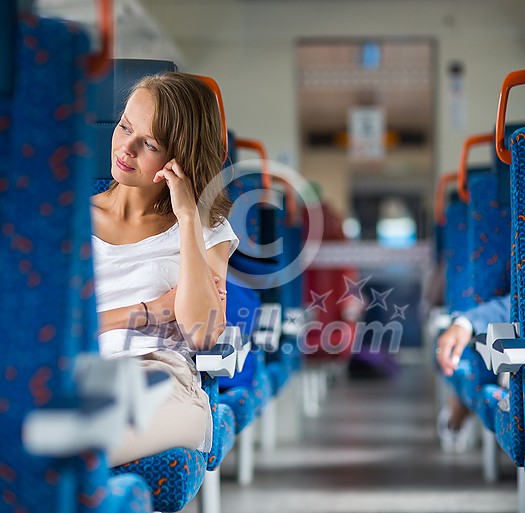 Young woman sitting in the train after a day of work . Train passenger traveling sitting relaxed and enjoying the ride Young woman sitting in the train after a day of work . Train passenger traveling sitting relaxed and enjoying the ride