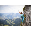 Pretty, female climber on a via ferrata -  climbing on a rock in Swiss Alps