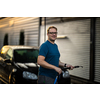 Young man washing his beloved car carefully in a manual car wash to prevent any damage and detail it properly