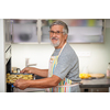 Senior man prepares healthy version of potatoes in the oven