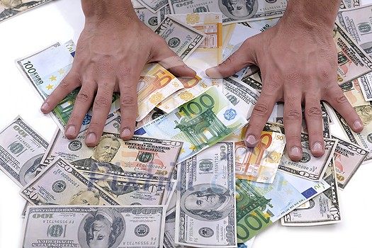 Portrait of a business man holding and catch falling money bills, isolated on white background in studio Portrait of a business man holding and catch falling money bills, isolated on white background in studio