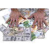 Portrait of a business man holding and catch falling money bills, isolated on white background in studio